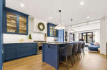 Experience luxury in this stunning kitchen featuring deep blue cabinetry and fluted glass upper cabinets.