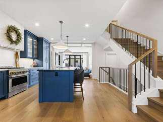 Experience modern luxury in this stunning kitchen featuring deep blue cabinetry and a spacious island perfect for entertaining.