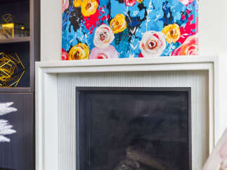 Elevate your living space with this stunning fireplace, featuring a vibrant floral artwork above and a sleek, modern design.