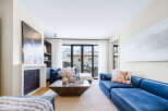 Experience modern living in this stunning living room, featuring plush blue velvet sectional sofas perfect for relaxation and entertaining.