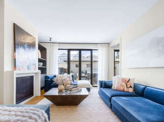 Experience modern living in this stunning living room, featuring plush blue velvet sectional sofas perfect for relaxation and entertaining.
