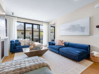 Experience modern living in this stunning living room, featuring plush blue velvet sofas that invite relaxation.