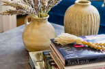 Elevate your living space with this stylish coffee table vignette, featuring a rustic ceramic vase filled with dried pampas grass and a stack of decorative books.