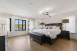 Experience luxury in this spacious master bedroom, featuring a king-sized bed with crisp white linens and plush pillows.