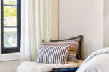 Experience ultimate comfort in this cozy reading nook, featuring a plush navy ottoman adorned with a luxurious white sheepskin throw.