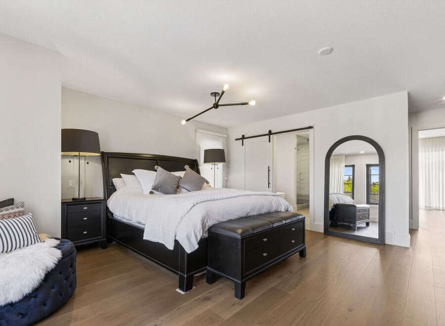 Experience luxury in this master suite, featuring a king-size bed with plush bedding and elegant bedside tables.