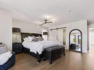 Experience luxury in this master suite, featuring a king-size bed with plush bedding and elegant bedside tables.