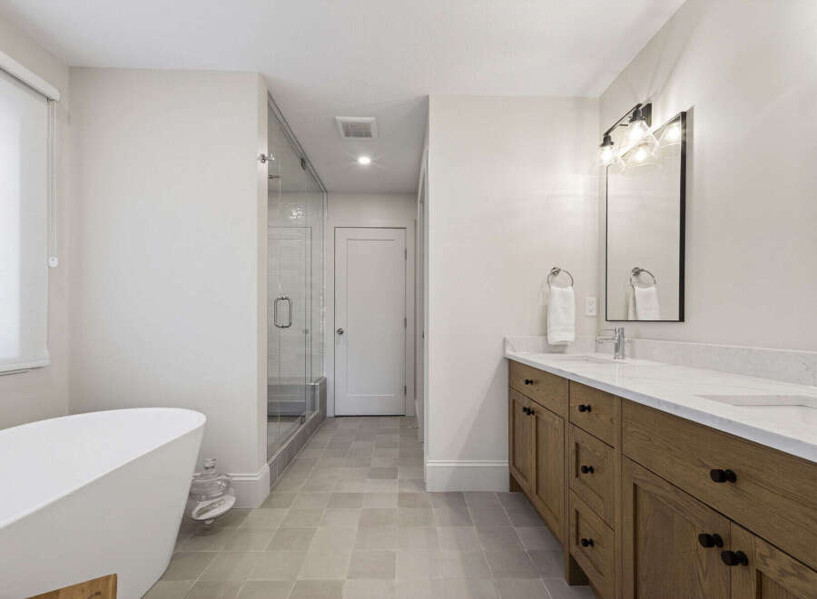 Experience luxury in this stunning bathroom featuring a freestanding soaking tub and a spacious glass-enclosed shower.