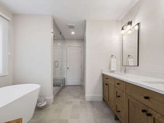 Experience luxury in this stunning bathroom featuring a freestanding soaking tub and a spacious glass-enclosed shower.