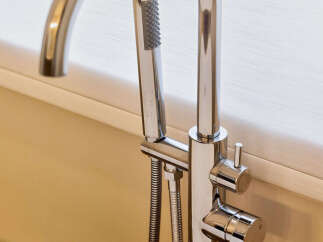 Experience luxury bathing with this modern freestanding bathtub faucet, featuring a sleek chrome finish and an integrated handheld showerhead.