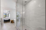 Experience modern luxury in this stunning bathroom featuring a spacious glass-enclosed shower with sleek white subway tile and a refreshing rain showerhead.
