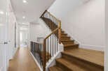 Ascend to the upper level via a beautifully crafted wooden staircase, featuring a modern black metal railing.