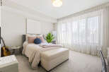 This bright and airy bedroom features a comfortable queen-size bed with plush pillows and a cozy throw.