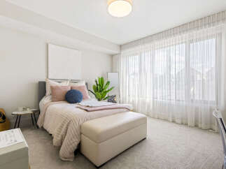 This bright and airy bedroom features a comfortable queen-size bed with plush pillows and a cozy throw.