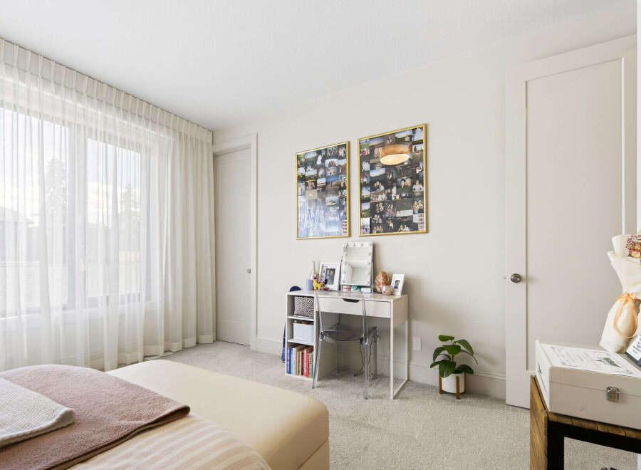 Bright and airy bedroom featuring sheer white curtains that allow natural light to flood the space.