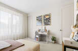 Bright and airy bedroom featuring sheer white curtains that allow natural light to flood the space.