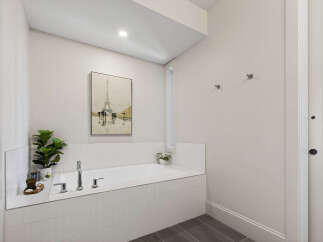 Indulge in relaxation in this luxurious bathroom featuring a spacious built-in bathtub surrounded by elegant white tilework.