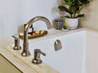 Experience luxury in this bathroom featuring a sleek, modern bathtub with a polished chrome faucet.
