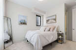 This charming bedroom features a comfortable queen-size bed adorned with crisp white linens and plush decorative pillows.