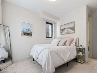 This charming bedroom features a comfortable queen-size bed adorned with crisp white linens and plush decorative pillows.