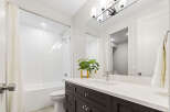 This modern bathroom features a sleek design with a white subway tile shower and a deep soaking tub.