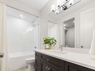 This modern bathroom features a sleek design with a white subway tile shower and a deep soaking tub.