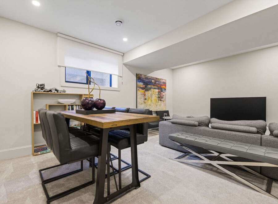 This modern living and dining area features a stylish high-top table with sleek chairs, perfect for casual meals or entertaining.