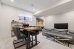 This modern living and dining area features a stylish high-top table with sleek chairs, perfect for casual meals or entertaining.