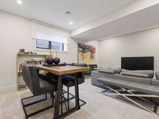 This modern living and dining area features a stylish high-top table with sleek chairs, perfect for casual meals or entertaining.