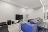 This modern living room features a spacious sectional sofa with plush throw pillows, perfect for relaxing.