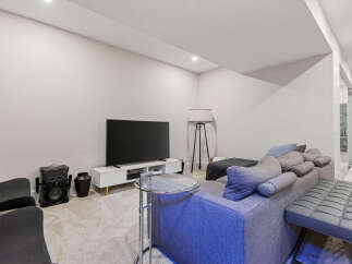 This modern living room features a spacious sectional sofa with plush throw pillows, perfect for relaxing.