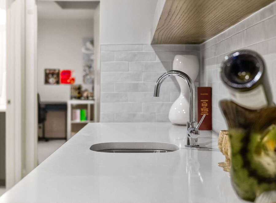 Discover modern elegance with this sleek countertop featuring a built-in sink and a stylish chrome faucet.