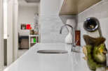 Discover modern elegance with this sleek countertop featuring a built-in sink and a stylish chrome faucet.