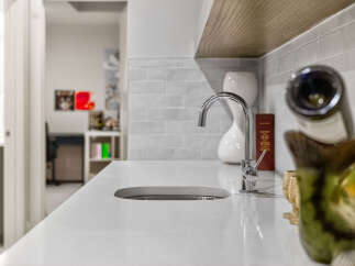 Discover modern elegance with this sleek countertop featuring a built-in sink and a stylish chrome faucet.