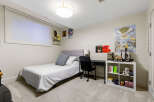 This bedroom features a comfortable twin bed with a tufted headboard, perfect for a guest room or child's space.