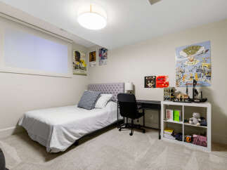 This bedroom features a comfortable twin bed with a tufted headboard, perfect for a guest room or child's space.