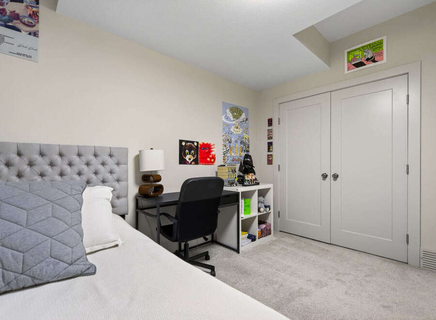 This bedroom features a stylish tufted headboard and a comfortable bed, perfect for relaxation.