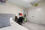 This bedroom features a stylish tufted headboard and a comfortable bed, perfect for relaxation.