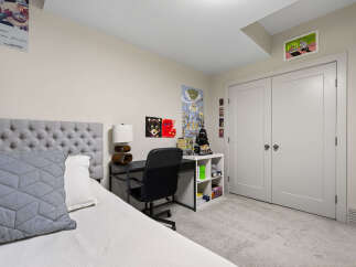 This bedroom features a stylish tufted headboard and a comfortable bed, perfect for relaxation.