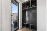 This entryway features a stylish dark gray built-in storage unit with open shelving and hooks, perfect for organizing coats and accessories.