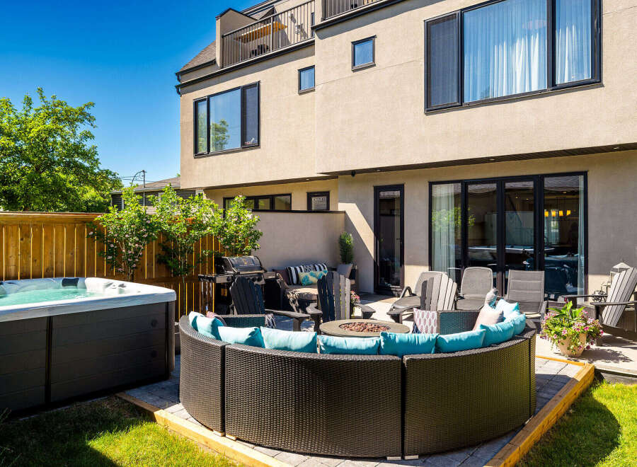 Enjoy outdoor living at its finest with this luxurious backyard oasis, featuring a relaxing hot tub and a spacious, modern patio area.