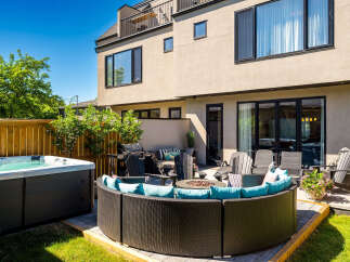 Enjoy outdoor living at its finest with this luxurious backyard oasis, featuring a relaxing hot tub and a spacious, modern patio area.