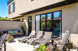 Enjoy outdoor living at its finest on this spacious patio, featuring comfortable lounge chairs and a stylish outdoor sofa perfect for relaxation.