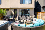 Enjoy outdoor living at its finest with this stunning patio featuring a luxurious sectional sofa, a cozy fire pit, and a premium gas grill.