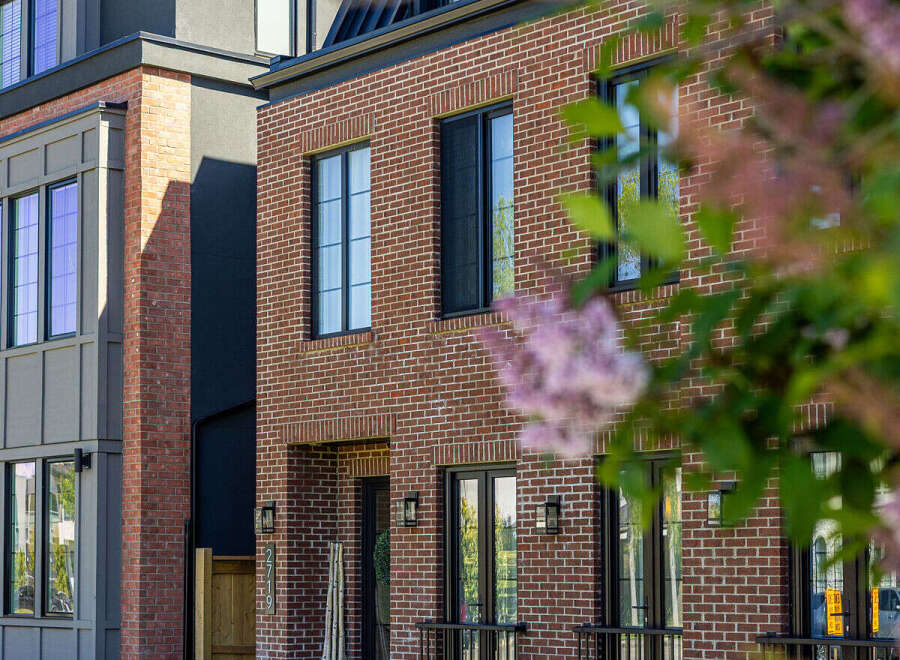 Discover modern urban living in this stunning townhouse featuring a striking brick facade and sleek, contemporary design elements.