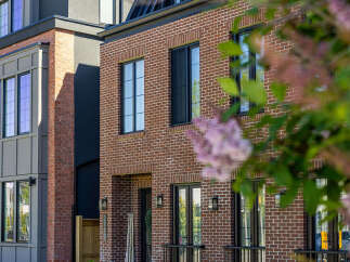 Discover modern urban living in this stunning townhouse featuring a striking brick facade and sleek, contemporary design elements.