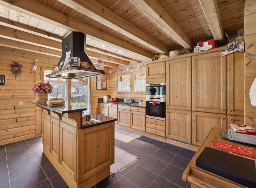 Experience rustic charm in this beautifully appointed log cabin kitchen, featuring warm wooden cabinetry and exposed beams.