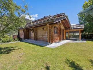 Experience serene mountain living in this charming wooden chalet, nestled amidst lush greenery and offering breathtaking views.
