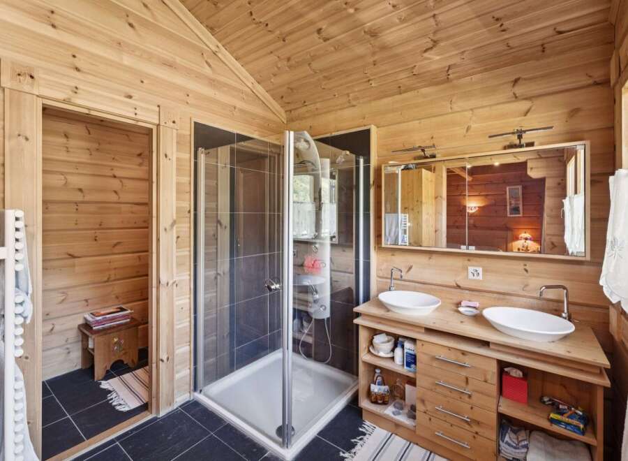 Experience rustic charm in this beautifully appointed bathroom featuring a spacious walk-in shower with sleek tilework.