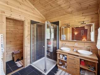 Experience rustic charm in this beautifully appointed bathroom featuring a spacious walk-in shower with sleek tilework.